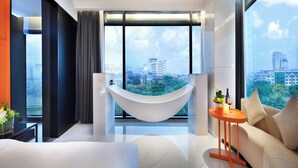 Un salón moderno con una hamaca, un sofá y vistas a la ciudad.