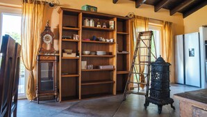 A kitchen with wooden shelves, a clock, and a ladder. - Horse guest house (Piemonte)