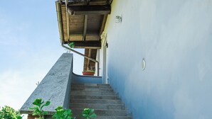 A staircase leading to a building with a blue exterior wall and a wooden roof. - Horse guest house (Piemonte)