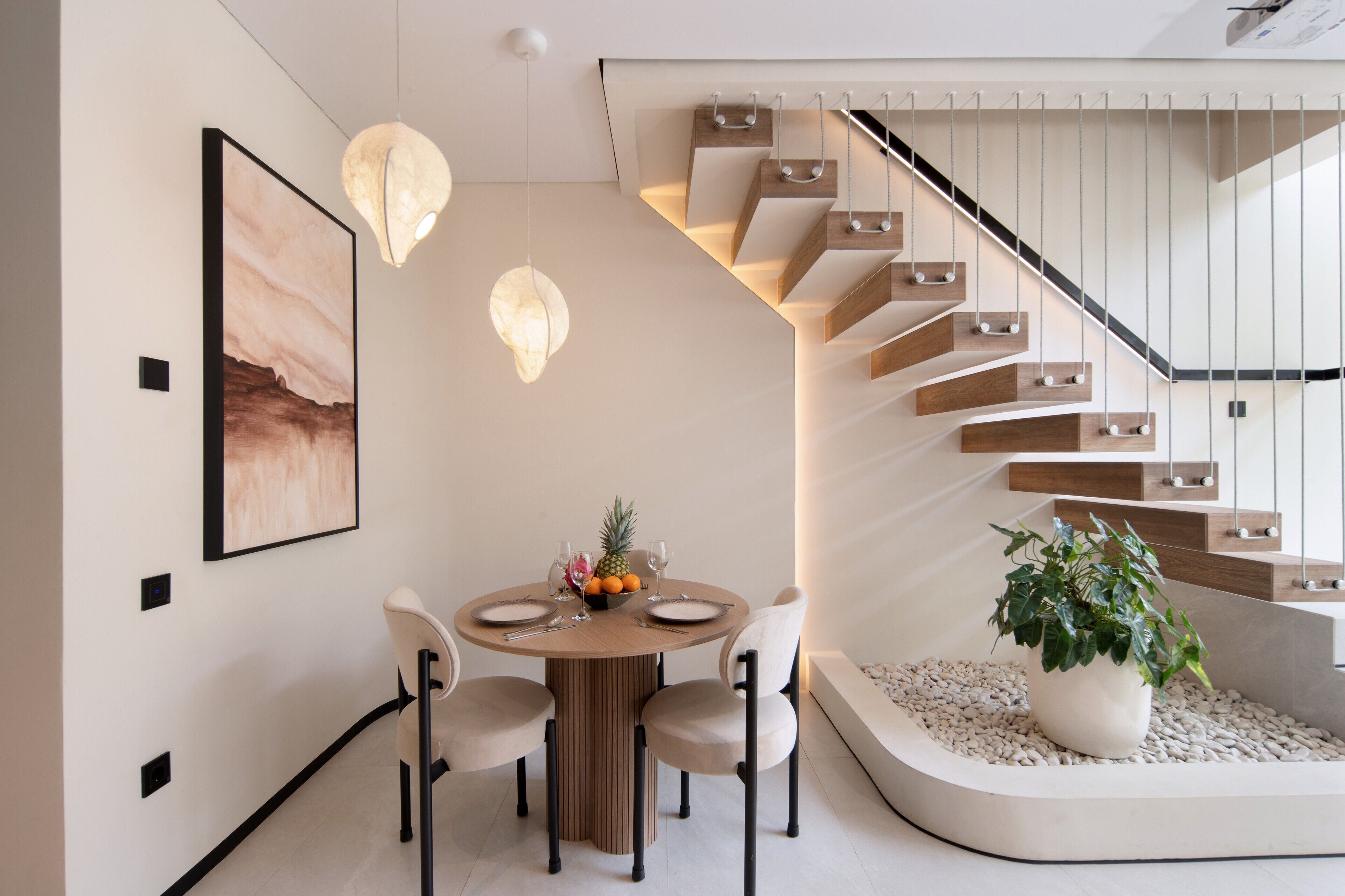 Un espace repas moderne avec une table ronde, des chaises et une plante en pot.