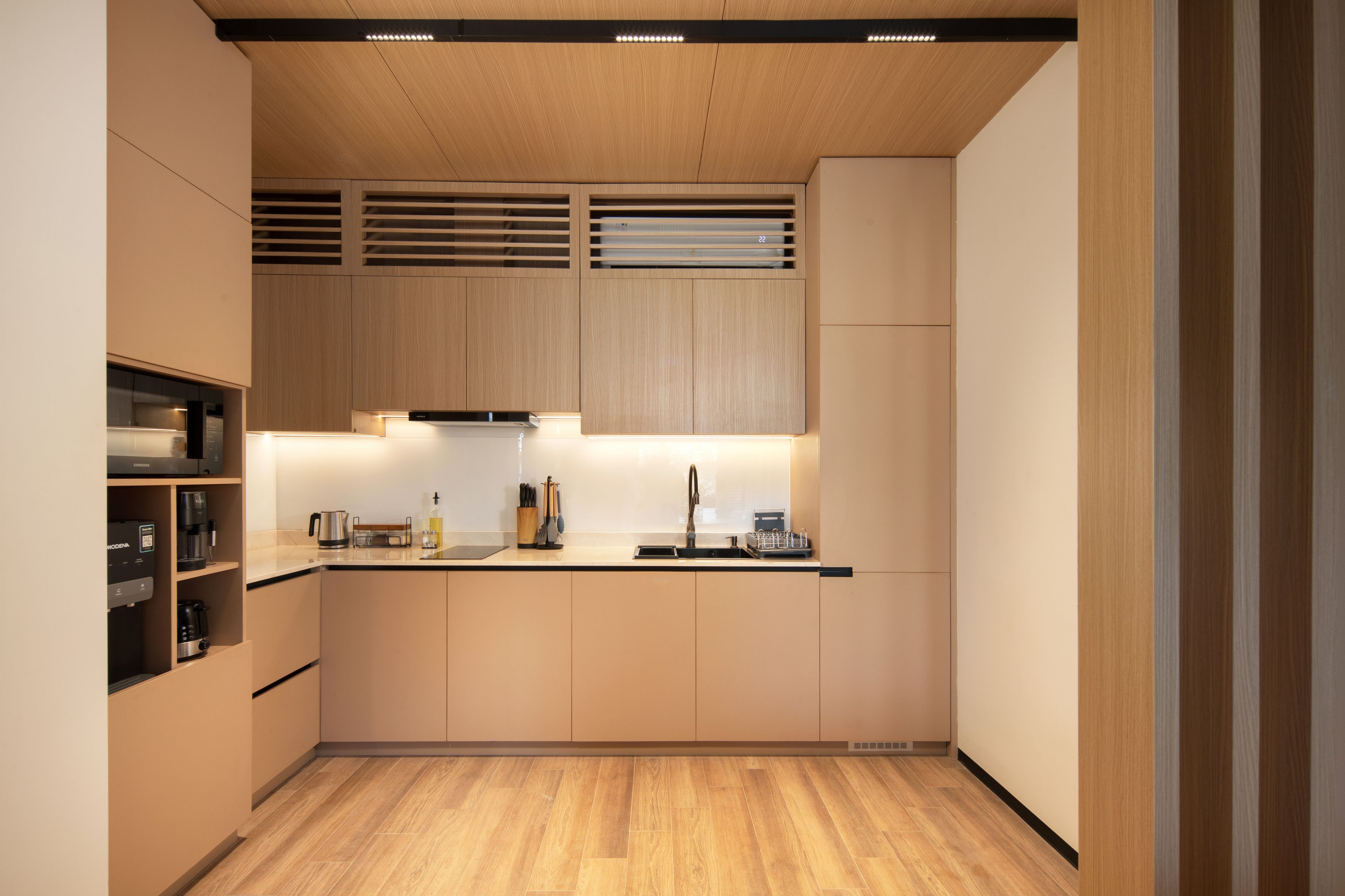A modern kitchen with wooden cabinets, a stainless steel sink, and a built-in range hood.