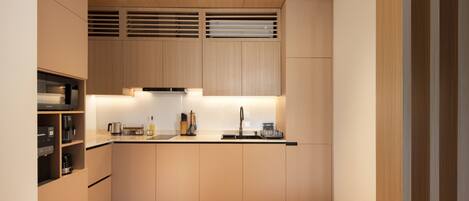 A modern kitchen with wooden cabinets, a stainless steel sink, and a built-in range hood.