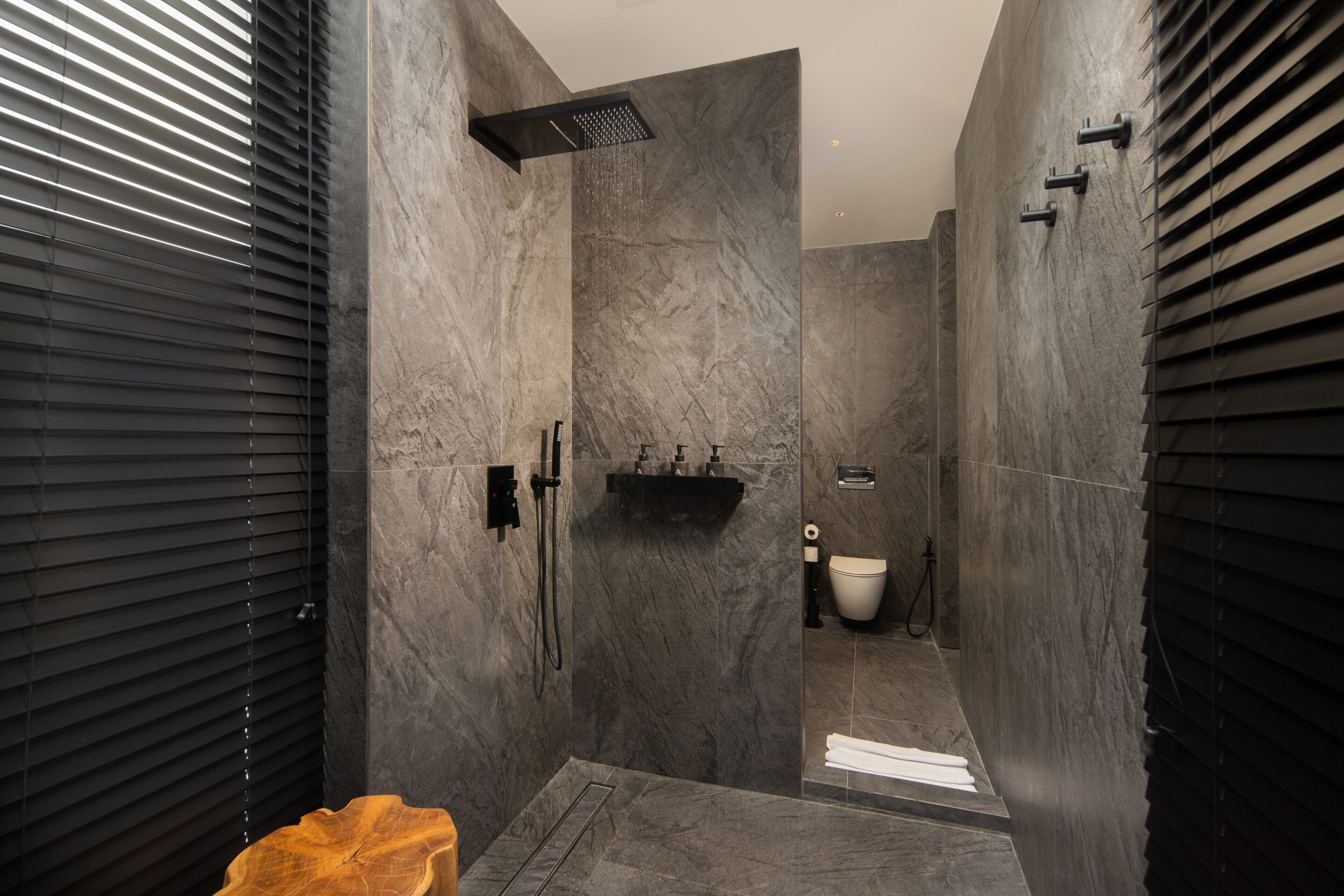 A modern bathroom with a shower, toilet, and sink.