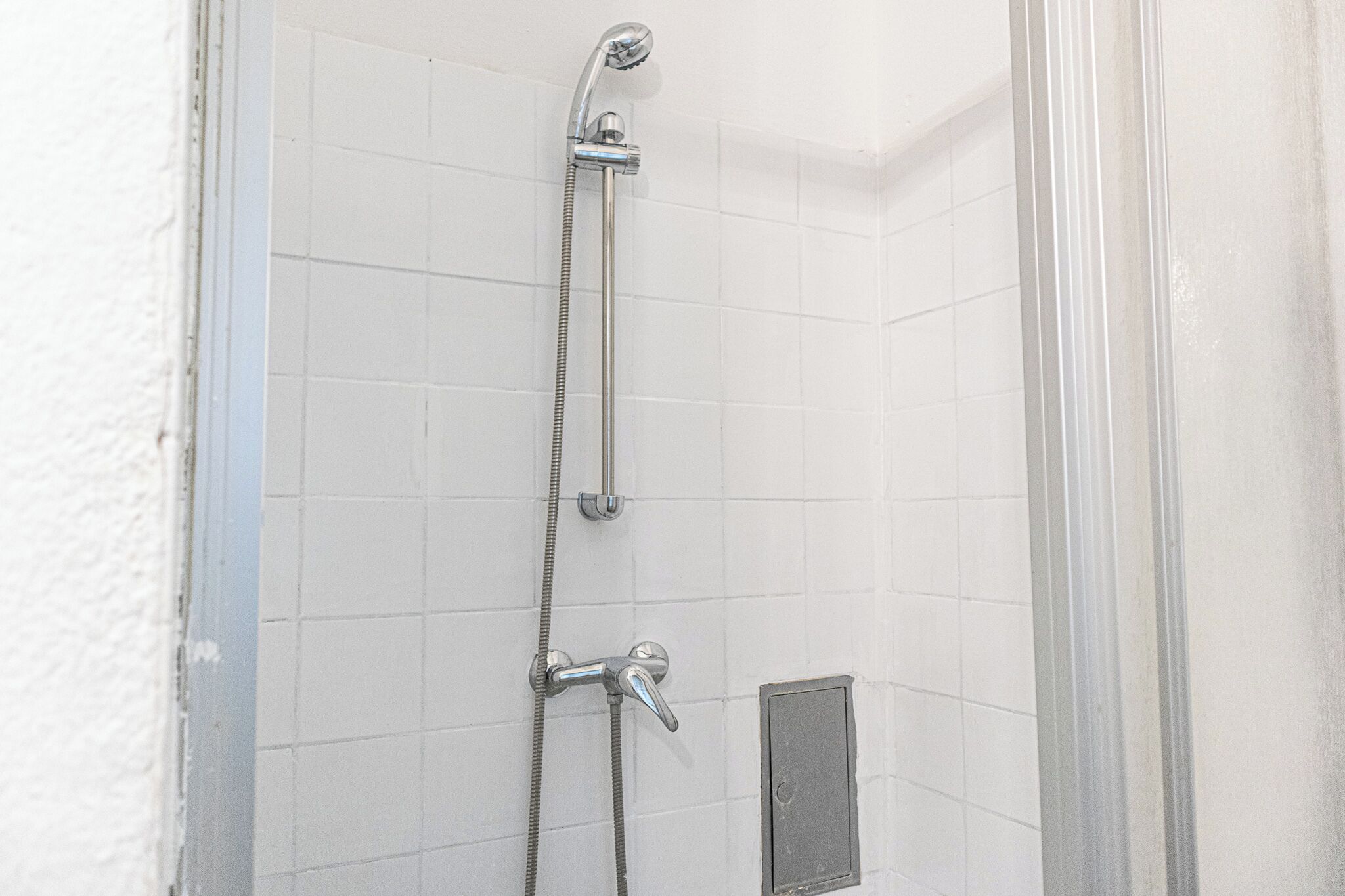 Eenvoudig appartement | Badkamer | Een douche, gratis toiletartikelen, een haardroger, handdoeken