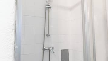 Eenvoudig appartement | Badkamer | Een douche, gratis toiletartikelen, een haardroger, handdoeken