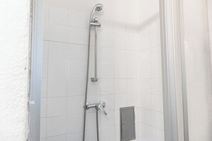 Eenvoudig appartement | Badkamer | Een douche, gratis toiletartikelen, een haardroger, handdoeken