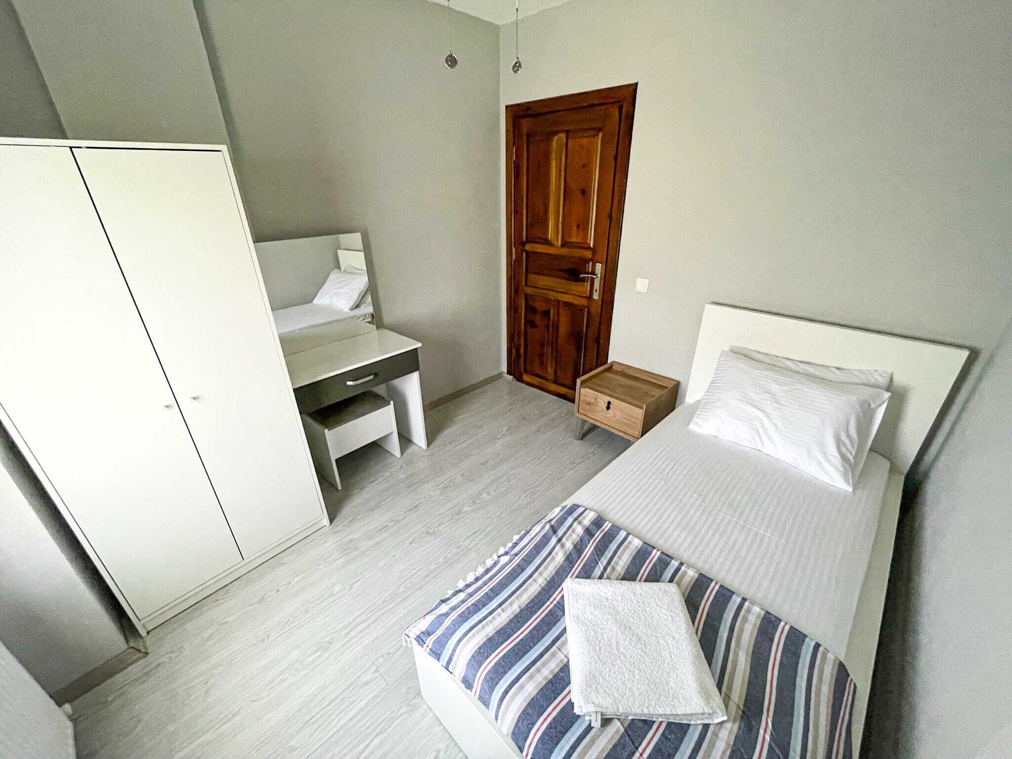 Un dormitorio con cama, escritorio y armario.