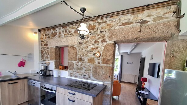 Eine Küche mit Steinwand, Backofen und Spüle.