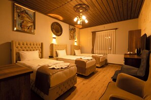 Una habitación de hotel con dos camas, un sofá, una silla, techo de madera y obras de arte en las paredes.