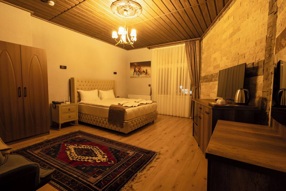 A bedroom with a bed, nightstand, and a wooden wardrobe.