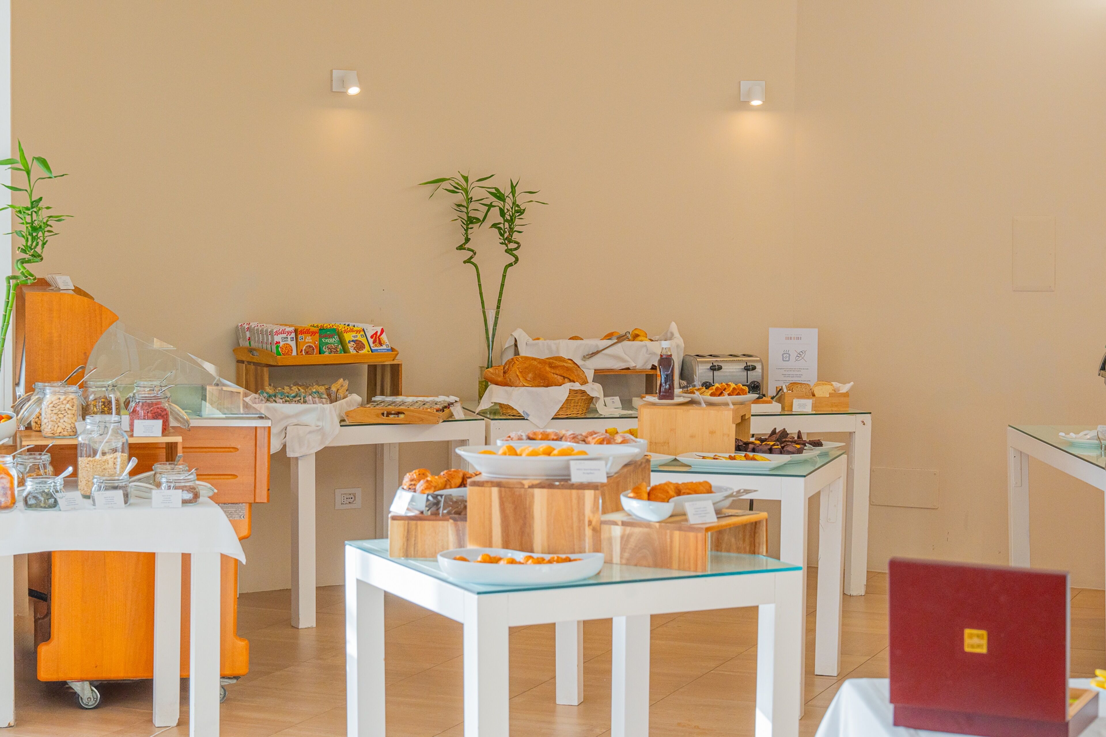 Mesa con una variedad de alimentos en estilo bufé y una computadora portátil.