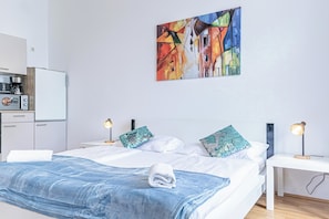 A modern hotel room with a bed, two bedside tables with lamps, a coffee machine, and a painting on the wall. - Affordable 2BR Apartment Near Belvedere (Vienna)