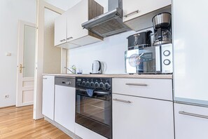 Eenvoudig appartement | Privékeuken | Een minikoelkast, een microgolfoven, een oven, een kookplaat