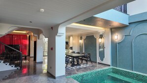 Un ampio interno con zona pranzo, una scala e area piscina.
