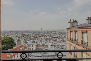 Une vue sur une ville, avec de nombreux bâtiments, dont une tour imposante qui se distingue au loin.
