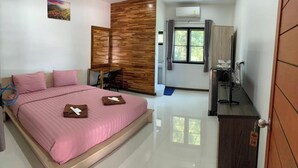 Ein Schlafzimmer mit Bett, Schreibtisch, Stuhl, Fernseher und Kleiderschrank.