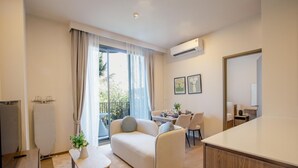 Una sala de estar moderna con un sofá, una mesita con una planta y un comedor con sillas y una mesa.