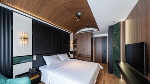 A modern bedroom with a large bed, a TV, and a wooden ceiling. - La Anima Hotel & Apartment (Da Nang)