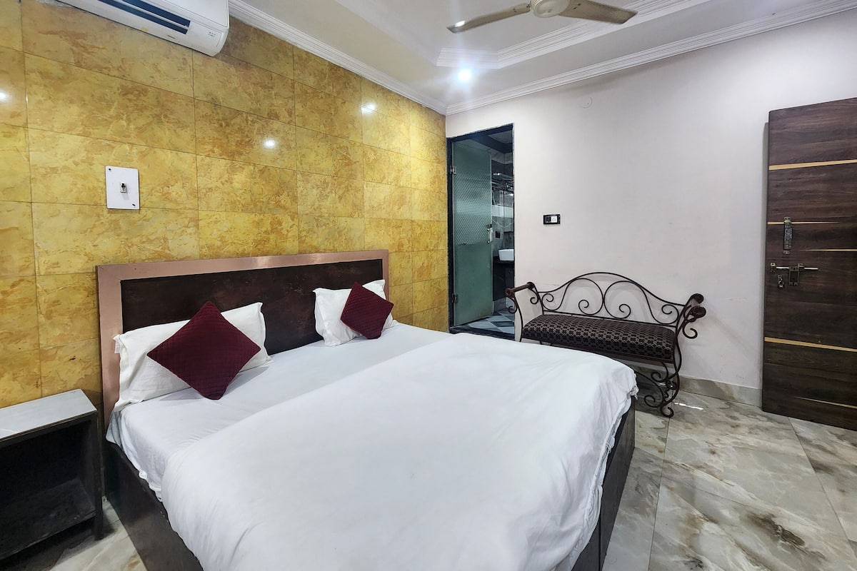 Ein Hotelzimmer mit Bett, Sitzbank, Kleiderschrank und Deckenventilator.