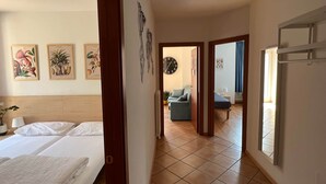 Habitación de hotel con cama, escritorio y silla. En la pared, impresiones enmarcadas de motivos botánicos.