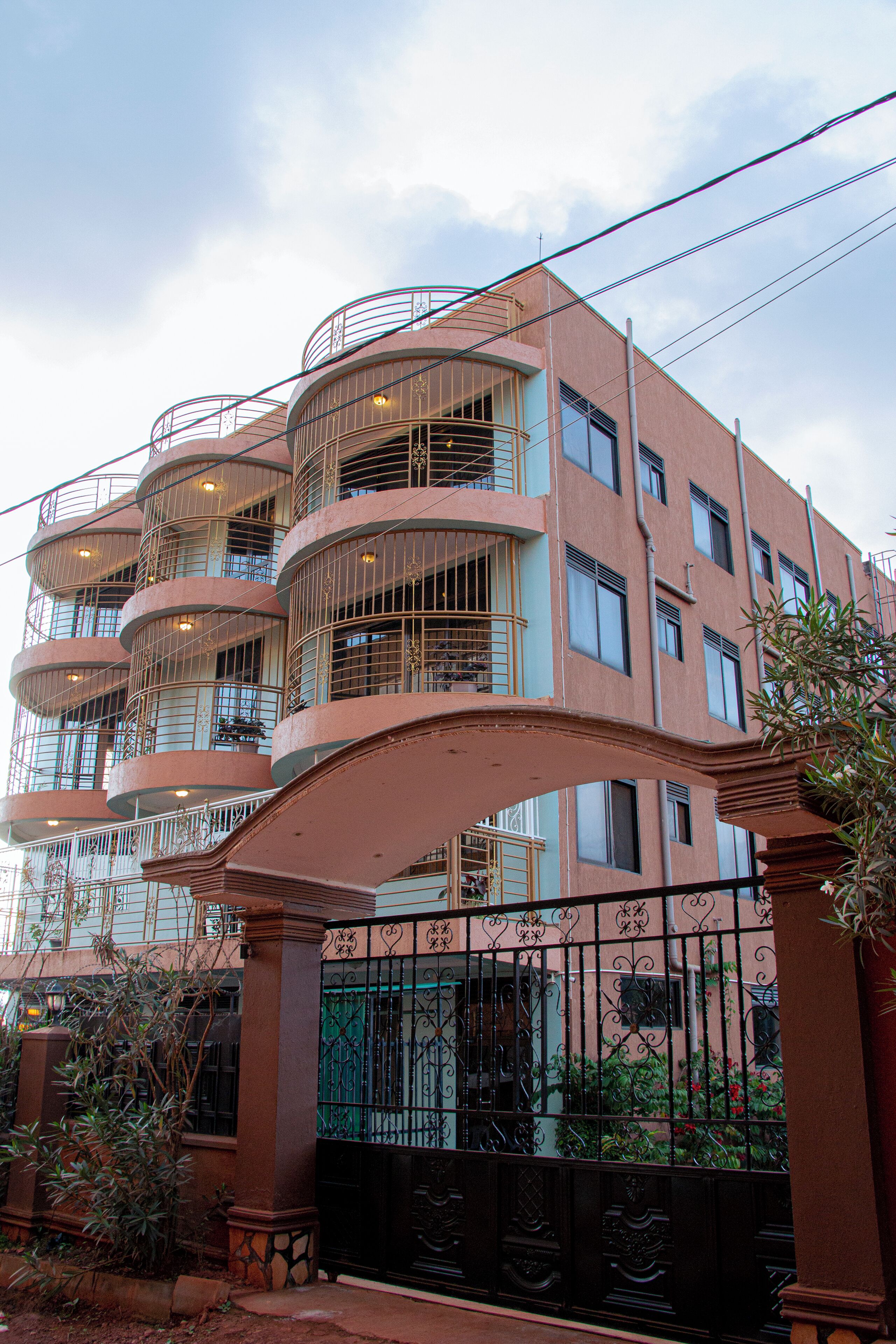 Um edifício com várias andares, varandas e portão fechado.