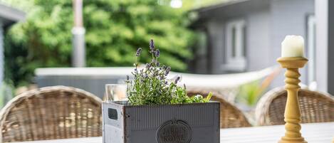 Un pot de fleurs en métal au style rustique, avec une plante et une bougie posés sur une table.