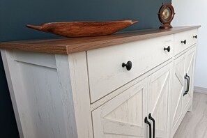 A white wooden dresser with drawers and a wooden top.