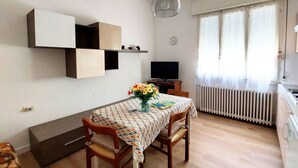 Een moderne keuken met een eethoek, een televisie en een radiator.