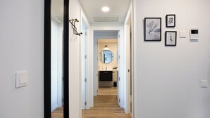 A hallway with wooden flooring, white walls, and framed artwork. - RivasCenter Apartment (Rivas-Vaciamadrid)