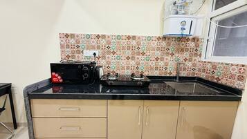 Kjøleskap, kokeplater, kjøkkenutstyr og spisebord