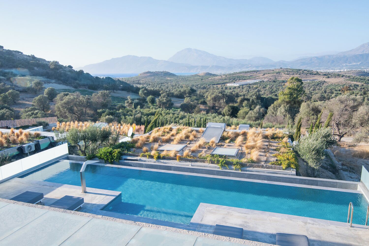 A rooftop pool with a view of a mountainous landscape.