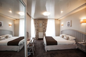 A hotel room with two beds, a desk, a chair, and a mirror. - Le Challonge (Dinan)