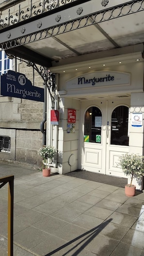 Entrada de un hotel con un cartel que dice 'Hôtel Marguerite 1820'.