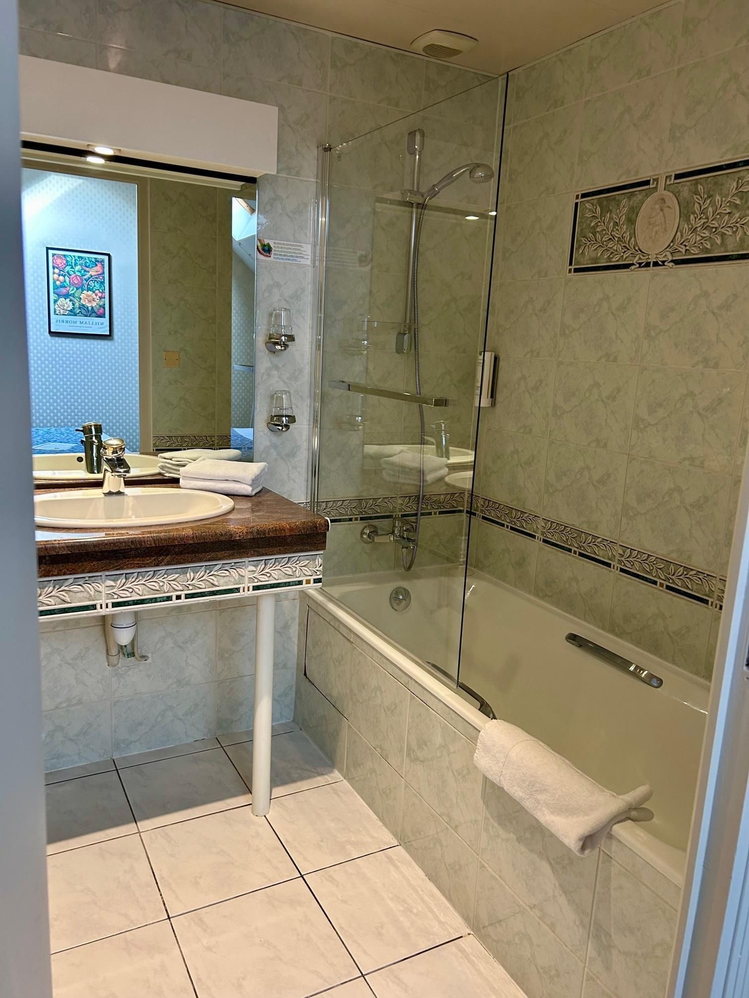 A modern bathroom with a glass-enclosed shower, a bathtub, and a vanity with a mirror.