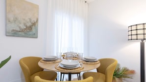 A dining area with a round table set for four, surrounded by mustard-colored chairs. - Central & Exclusive 2BD Apartment in Cordoba. Hinojo (Córdoba)