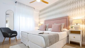 A bedroom with a bed, bedside tables, a chair, a mirror, and a ceiling fan. - Central & Exclusive 2BD Apartment in Cordoba. Hinojo (Córdoba)