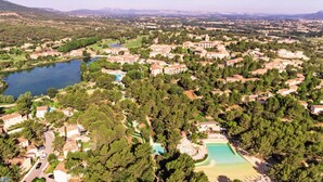 Vista aérea de una zona residencial con varios edificios, un lago y un campo de golf.