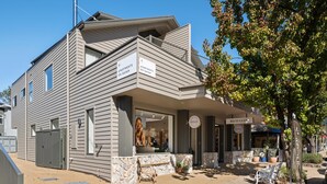 A two-story building with a sign indicating 'Apartments on Gavan'. - Apartment Two - Apartments on Gavan - Welcome to Your Luxurious Getaway at Apartments on Gavan. (Bright)