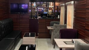 A modern bar area with seating and a television screen. - Century 24 Hotel and Suites  (Lagos)