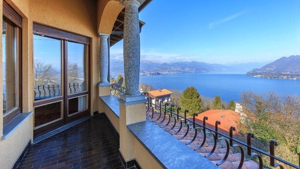 A balcony with a view of a lake and mountains.