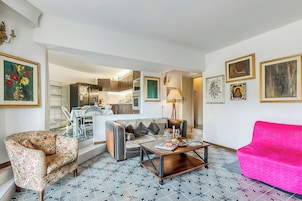 A living room with a patterned floor, a sofa, a coffee table, and a bright pink couch.