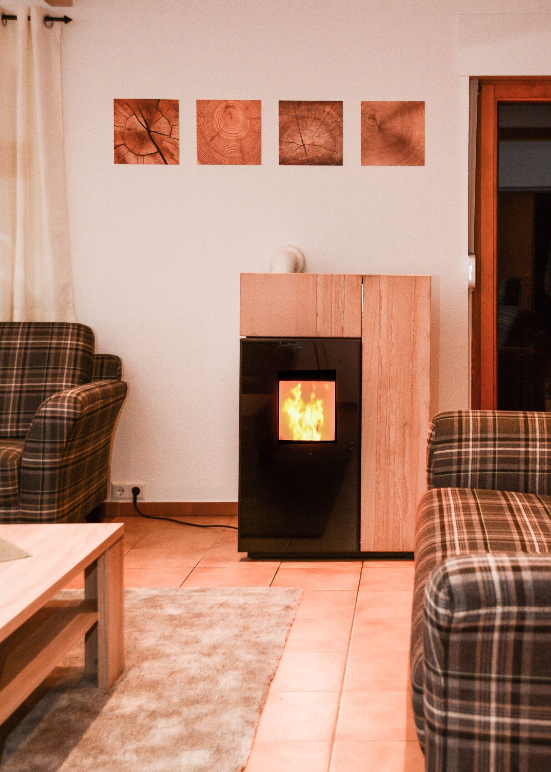 Ein Wohnzimmer mit Kamin, Karo-Möbeln und Wandbildern.