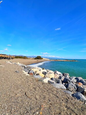 A rocky beach with a clear blue sky and calm sea. - Guadalmar House by Residea (Churriana)