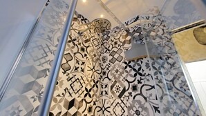 A shower with a geometric tile pattern and a glass enclosure. - Lovely Rhome  apartment near Vatican (ROMA)