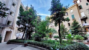 A courtyard with potted plants, a street lamp, and buildings with balconies. - Lovely Rhome  apartment near Vatican (ROMA)