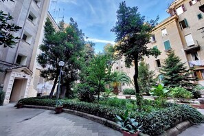 A courtyard with potted plants, a street lamp, and buildings with balconies. - Lovely Rhome  apartment near Vatican (ROMA)