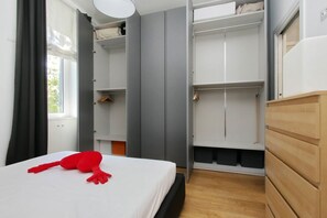 Un dormitorio con cama, armario y ropero.