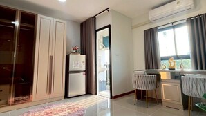 A modern apartment with a kitchenette, a dining area, and a large wardrobe. - ✈️ How to Get from Don Mueang Airport to The Rise 789 (Tambon Lak Hok)