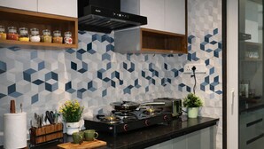 Une cuisine moderne équipée d’une cuisinière à gaz, d’un grille-pain et de divers ustensiles disposés sur le plan de travail.