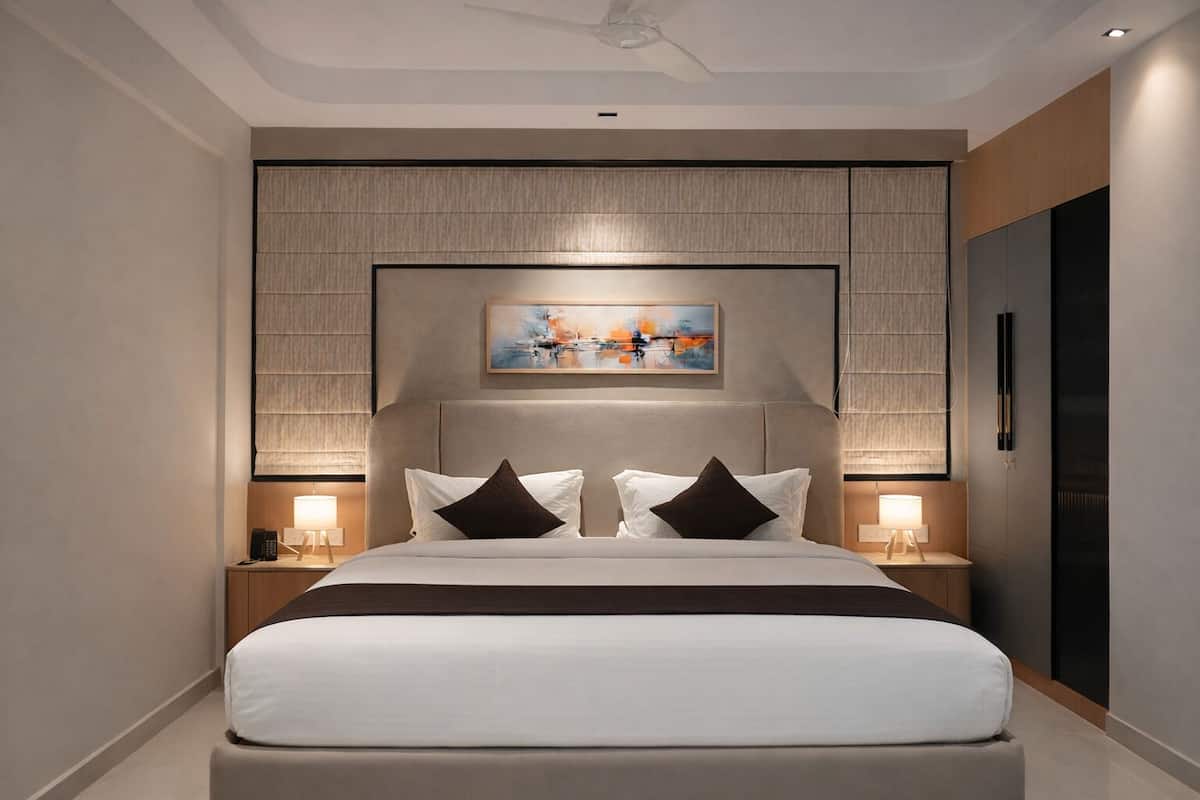 Ein modernes Hotelzimmer mit einem großen Bett, zwei Nachttischen, einem Deckenventilator und einem Gemälde über dem Bett.